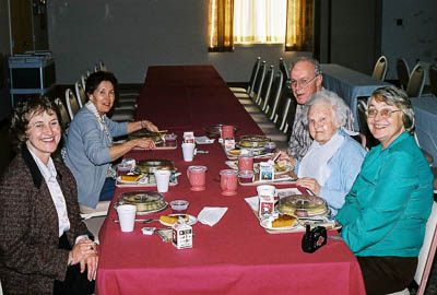 A group of old people sitting at a table

Description automatically generated