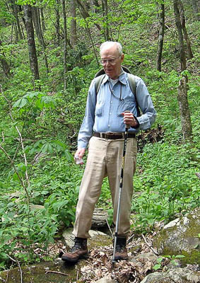 An old person hiking in the woods

Description automatically generated